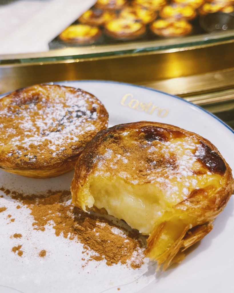 Pastéis De Nata covered in cinnamon and powdered sugar from Castro in Lisbon, Portugal
